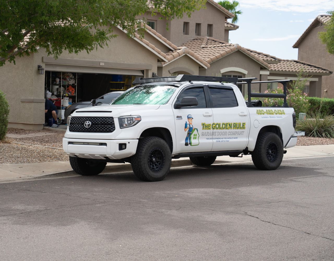 The Golden Rule Garage Door Company service truck outside a residential home